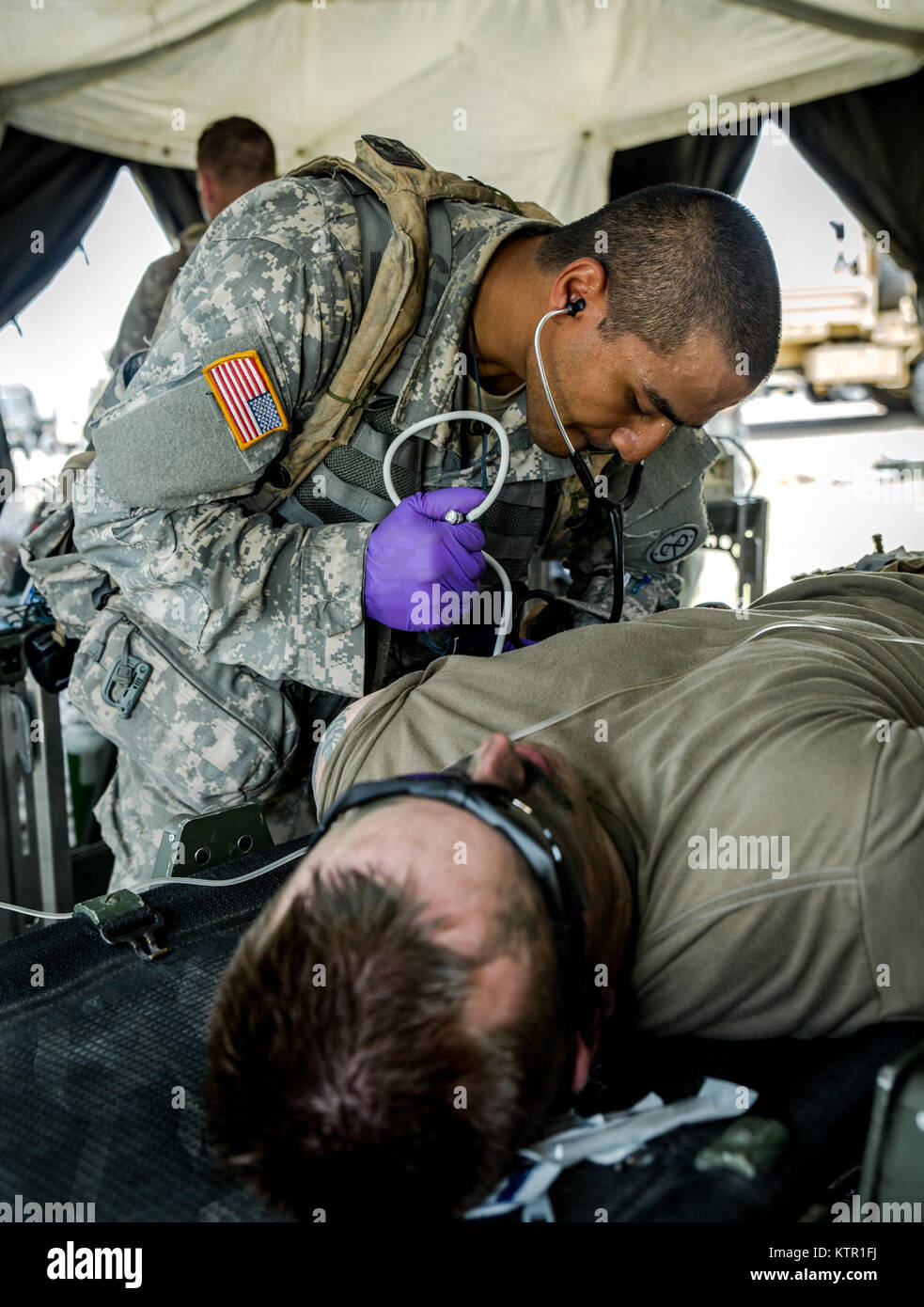 New York Army National Guard Spc. Muhammad Alam, assigned to Headquarters Co., 1st Battalion, 69th Infantry, checks a Soldier's blood pressure during a mass casualty exercise at the Army’s Joint Readiness Training Center, Fort Polk, La., Saturday, July 16, 2016. More than 3,000 New York Army National Guard Soldiers deployed for a three week exercise at the Army’s Joint Readiness Training Center, July 9-30, 2016. U.S. Army National Guard photo by Sgt. Harley Jelis. Stock Photo