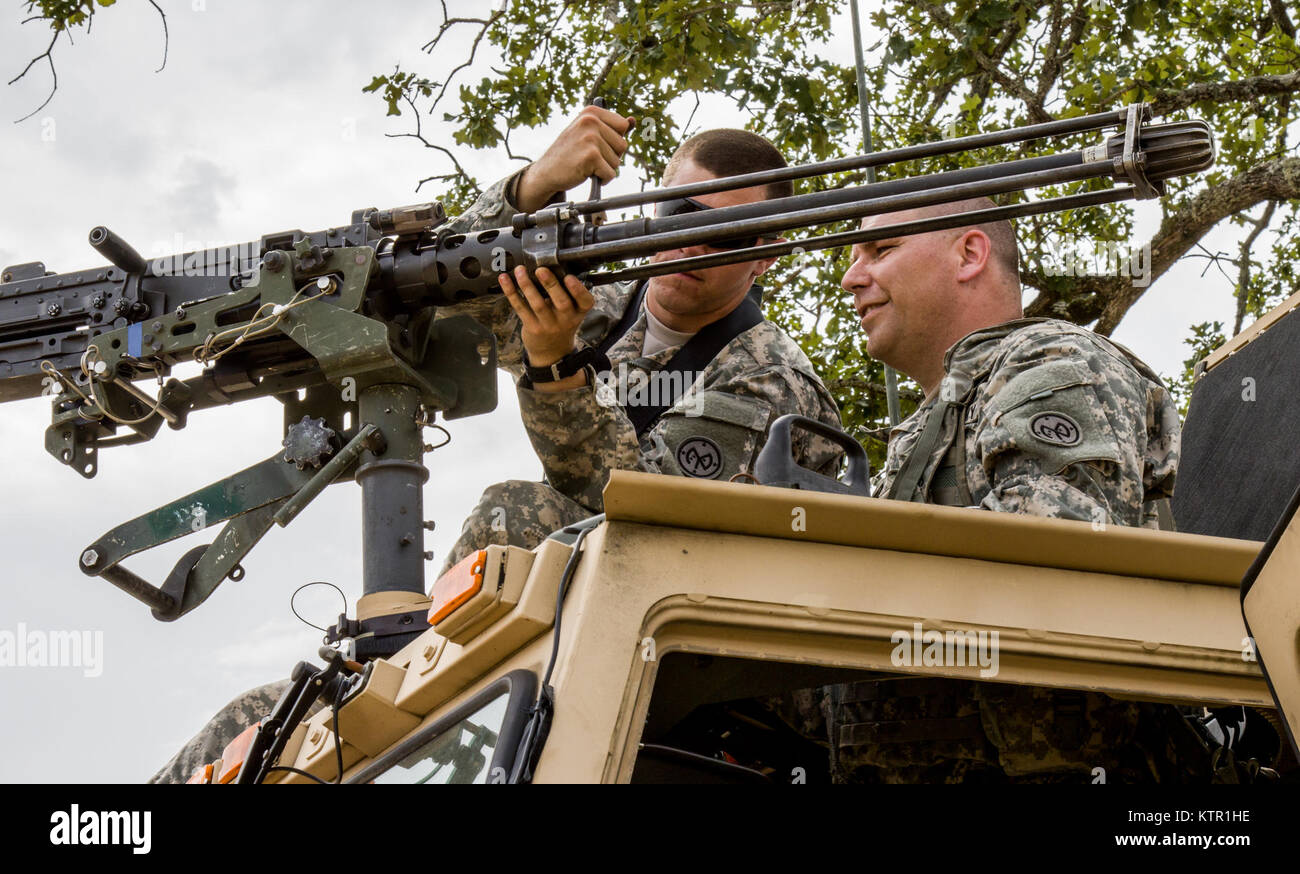 New York Army National Guard Pfc. Tyler Miner (left) and Sgt. 1st Class Scott Dingmon, infantrymen with the 2nd Battalion, 108th Infantry, attach an M2, .50-caliber machine gun to the roof of a tactical vehicle at the Army’s Joint Rotational Training Center, Ft. Polk, La., July 16, 2016.   More than 3,000 New York Army National Guard Soldiers deployed to Fort Polk, Louisiana for a three-week exercise at the Army’s Joint Readiness Training Center, July 9-30, 2016. Stock Photo