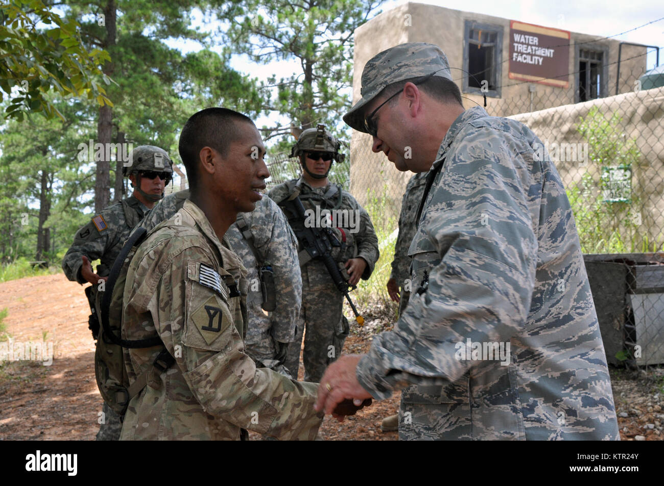 Massachusetts Air National Guard Maj. Gen. Gary Keefe, the Massachusetts National Guard Adjutant General, presents a challenge coin to Sgt. Kim Kheav, an infantryman assigned to Co. C, 1st Battalion, 182nd Infantry based in Braintree, Mass. during training at the Army’s Joint Readiness Training Center, Fort Polk, Louisiana, Wednesday, July 20, 2016. Kheav received the coin for his outstanding performance during training. Nearly 700 Soldiers from the Massachusetts Army National Guard joined over 3,000 Soldiers of New York’s 27th Infantry Brigade Combat Team and another 1,000 Soldiers from other Stock Photo