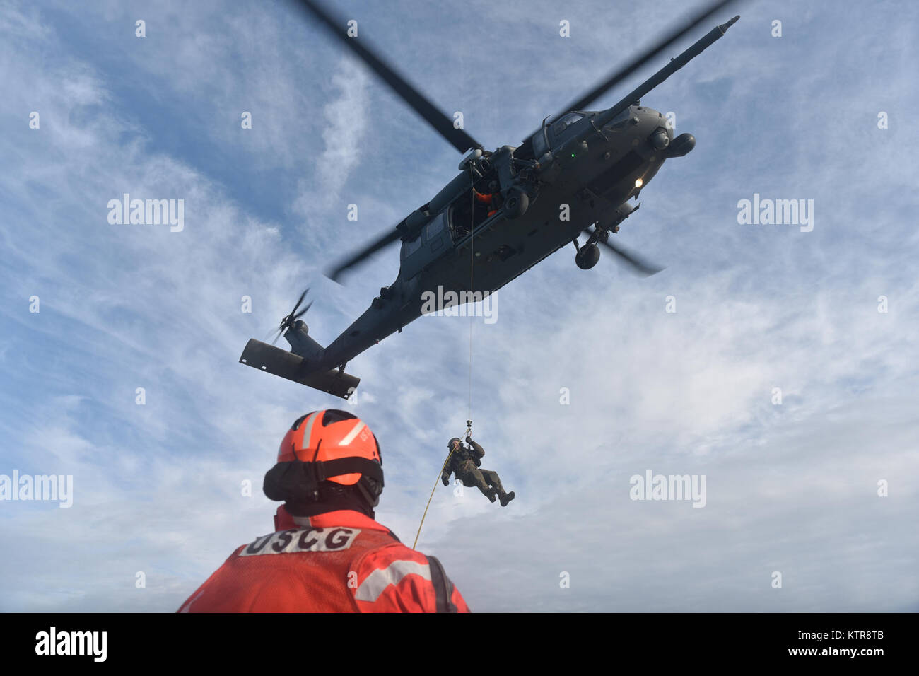 HAMPTON BAYS, NY - Airmen with 101st Rescue Squadron and 103rd Rescue Squadron conduct hoist training with United States Coastguardsmen from  US Coast Guard Station Shinnecock December 22, 2016.  During this training, Guardian Angels from the 103rd RQS were lowered via hoist from an HH-60 Pavehawk onto the cutter's deck. After that, the aircraft practiced dropping and removing patient litters, before hoisting the Guardian Angels back up and returning to base.  (US Air National Guard / Staff Sergeant Christopher S. Muncy / released) Stock Photo