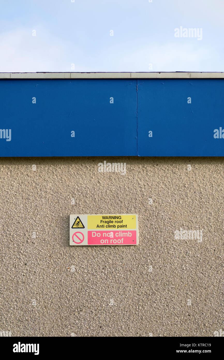 Do Not Climb on Fragile Roof Structure at School Building Anti Climb Paint Sign on Wall Stock Photo