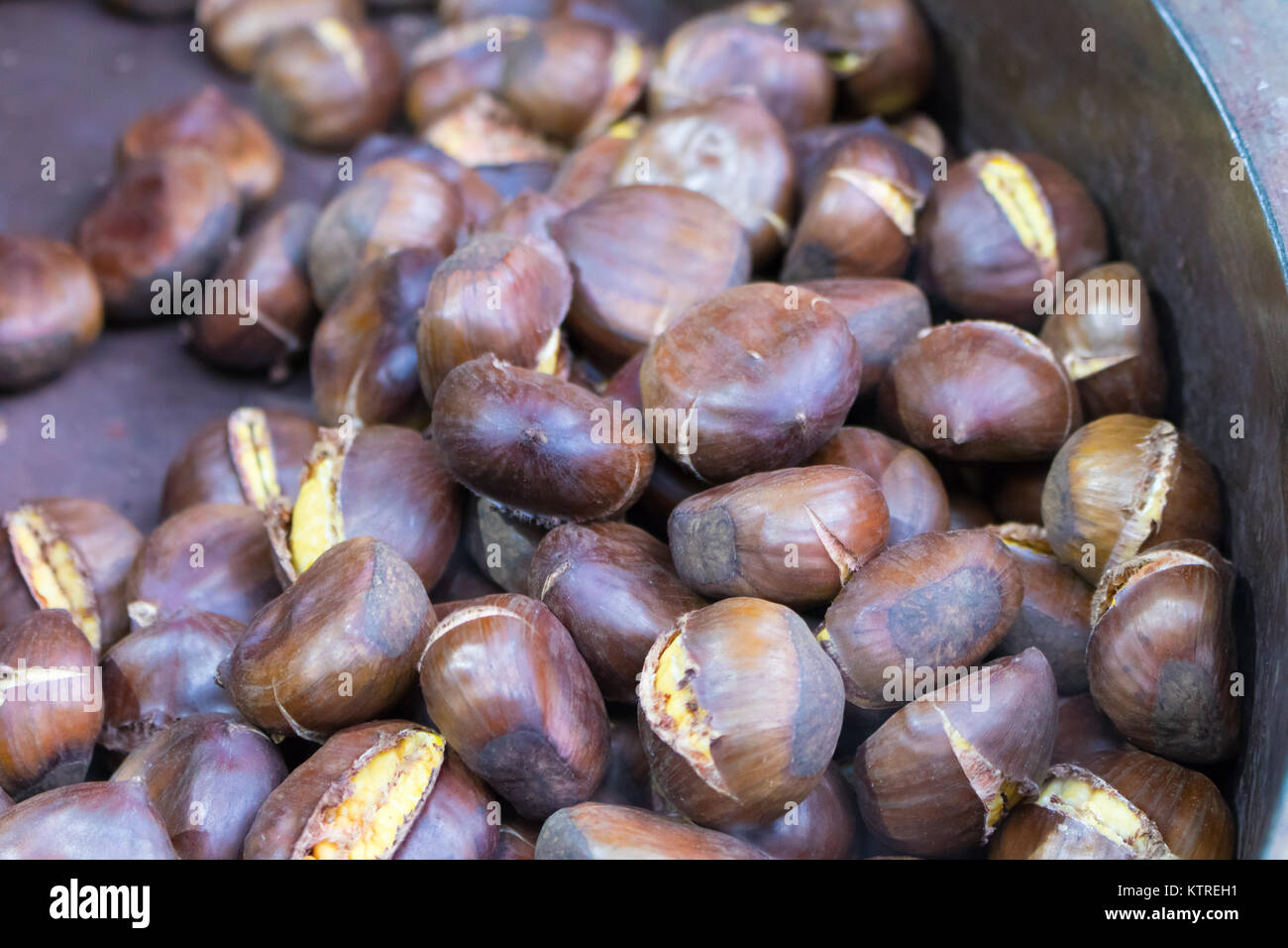 Street food market. Roasting brown chestnuts in a big pot.Winter Stock Photo