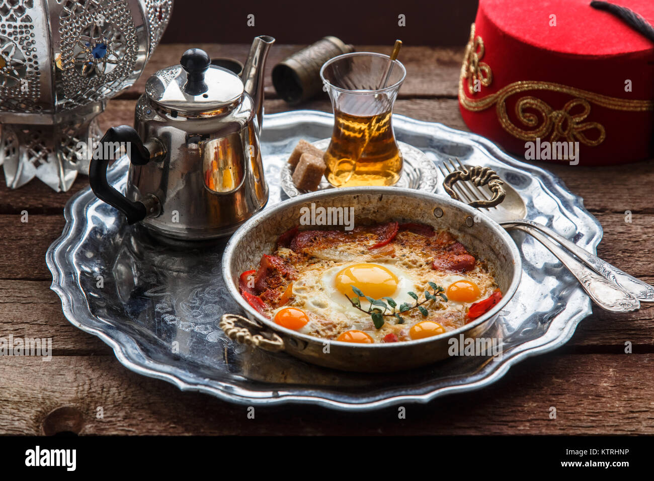 Fried egg with cured meat, traditional turkish breakfast, served in metal dishware, rustic Stock Photo