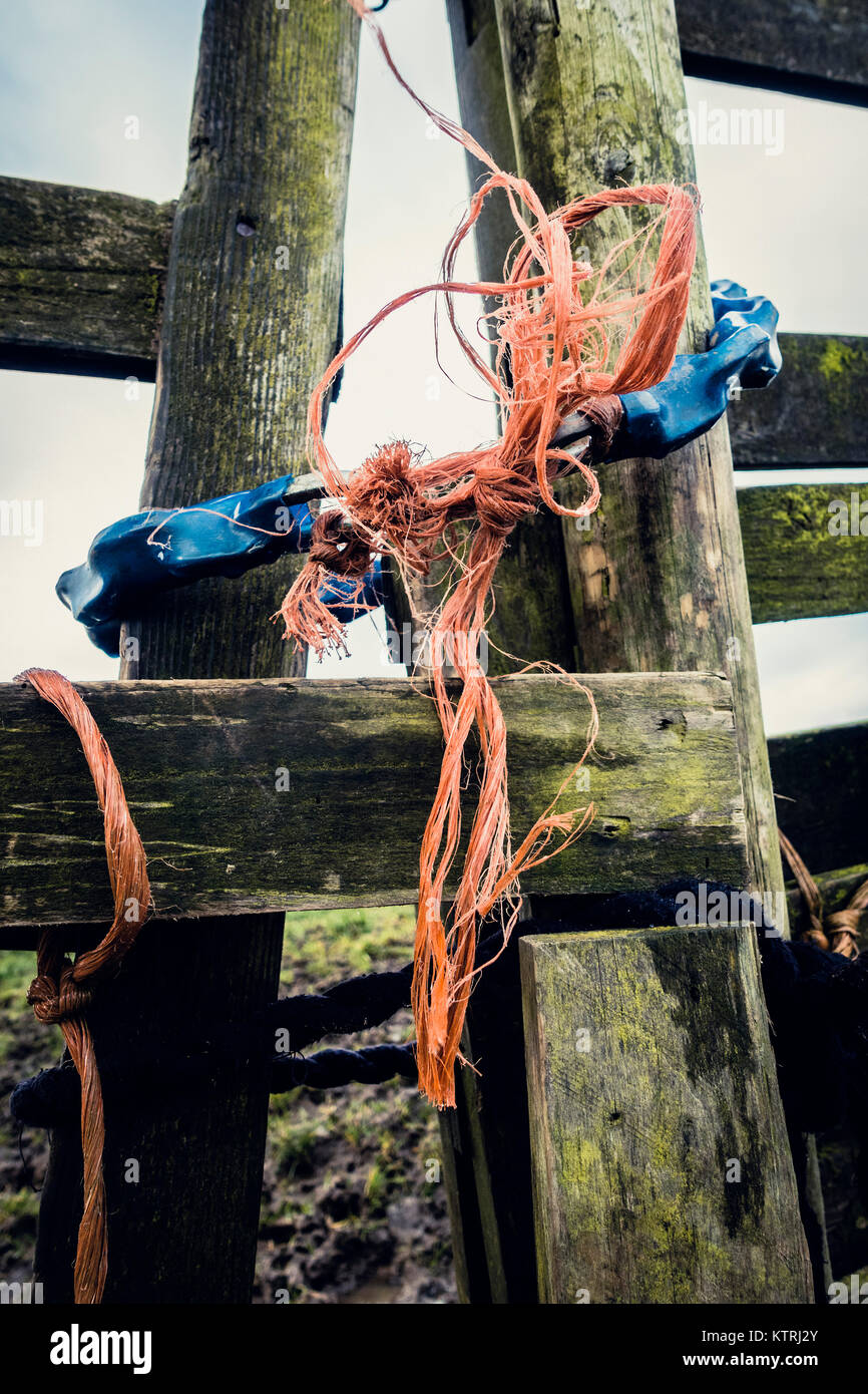 A chain and some frayed orange twine on a rickety old wooden gate Stock Photo