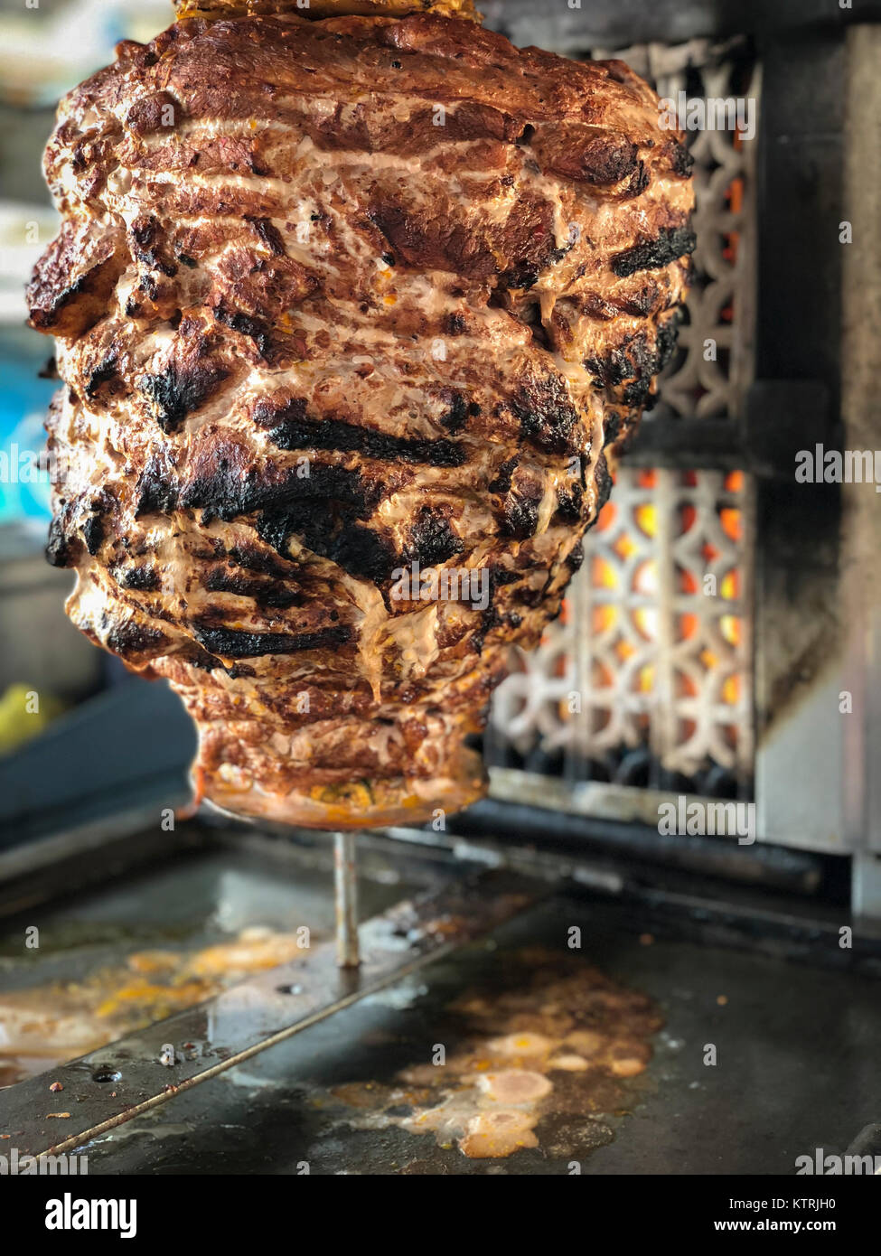 Close up of vertical spit in front of grilling heat source for tacos al pastor - a Mexican street food specialty. Stock Photo
