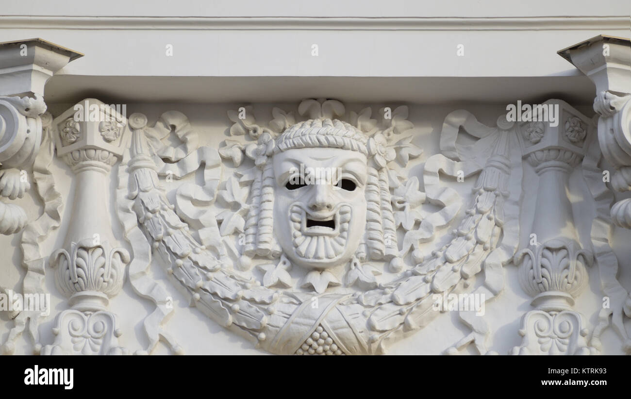 Plaster mask on the wall of the theater.It is a symbol of Comedy. Stock Photo