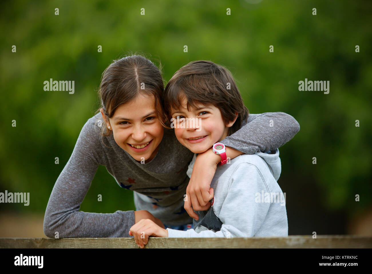 Sister giving her younger brother a hug Stock Photo
