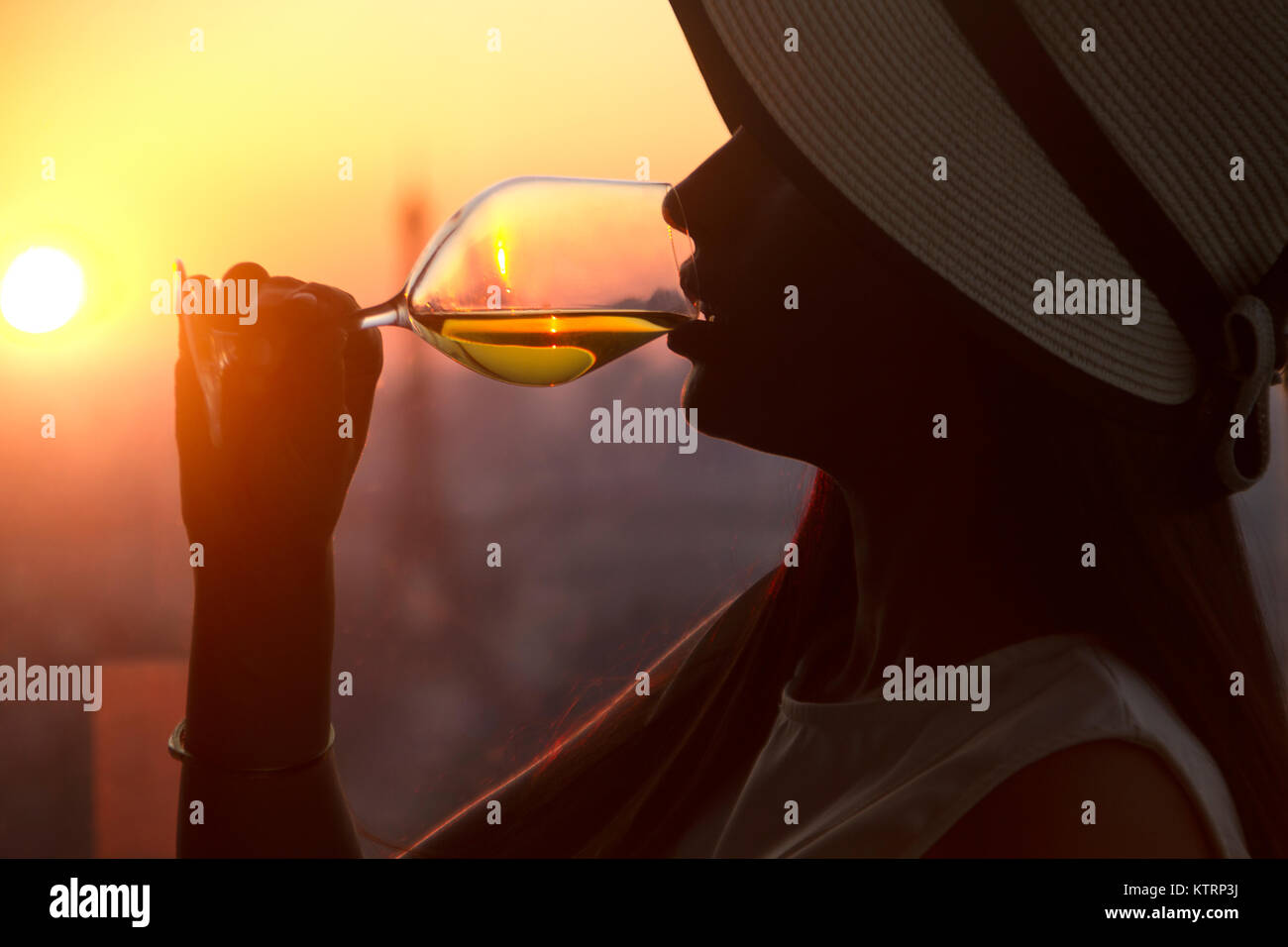 Girl drinking white wine glass at the sunset in Paris city with view at