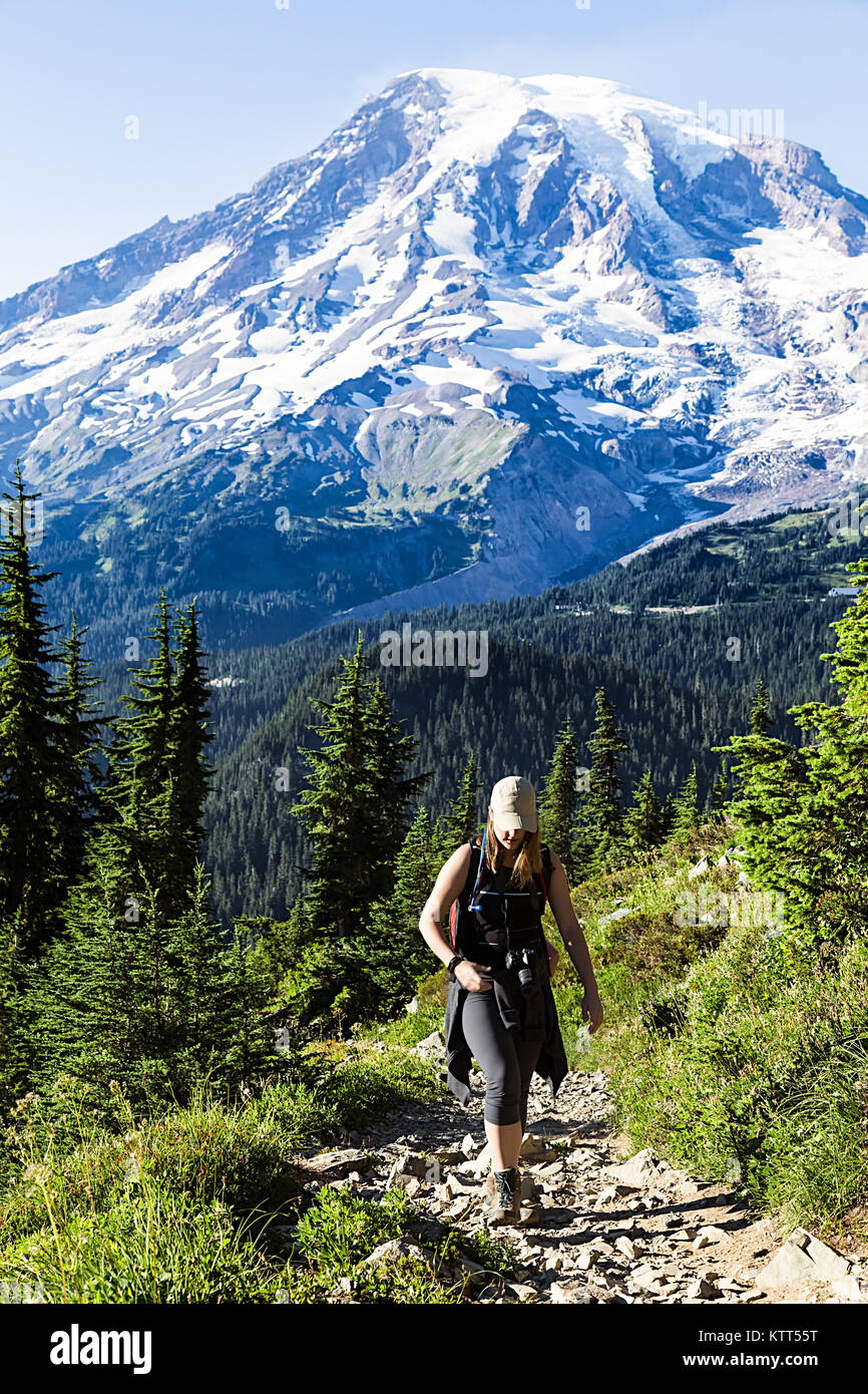 Woman hiking along mountain trail, Mount Rainier National Park, Washington, United States Stock Photo