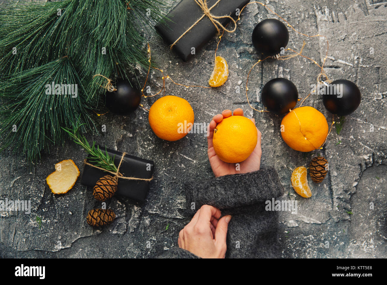 Woman's hands holding fresh satsumas and Christmas gifts Stock Photo