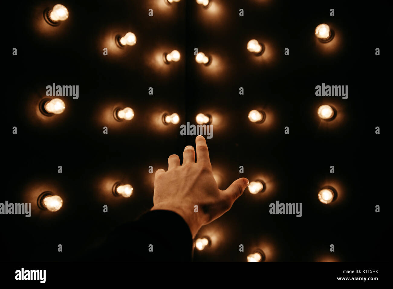 Human hand reaching for light bulbs Stock Photo