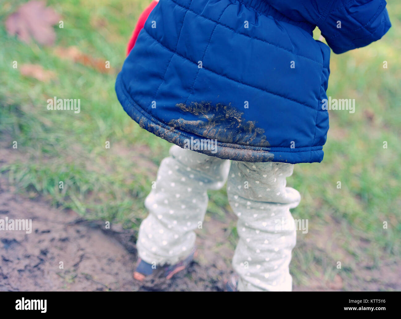 Close-up of a girl with mud on her coat Stock Photo