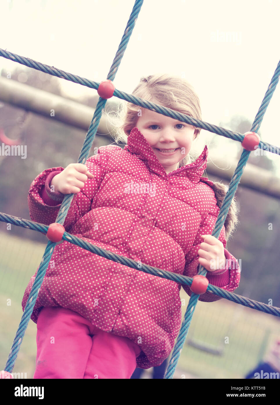Smiling girl on a climbing frame Stock Photo