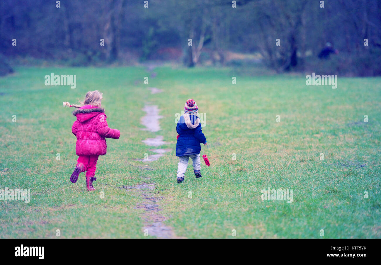 Two girls running in a public park Stock Photo