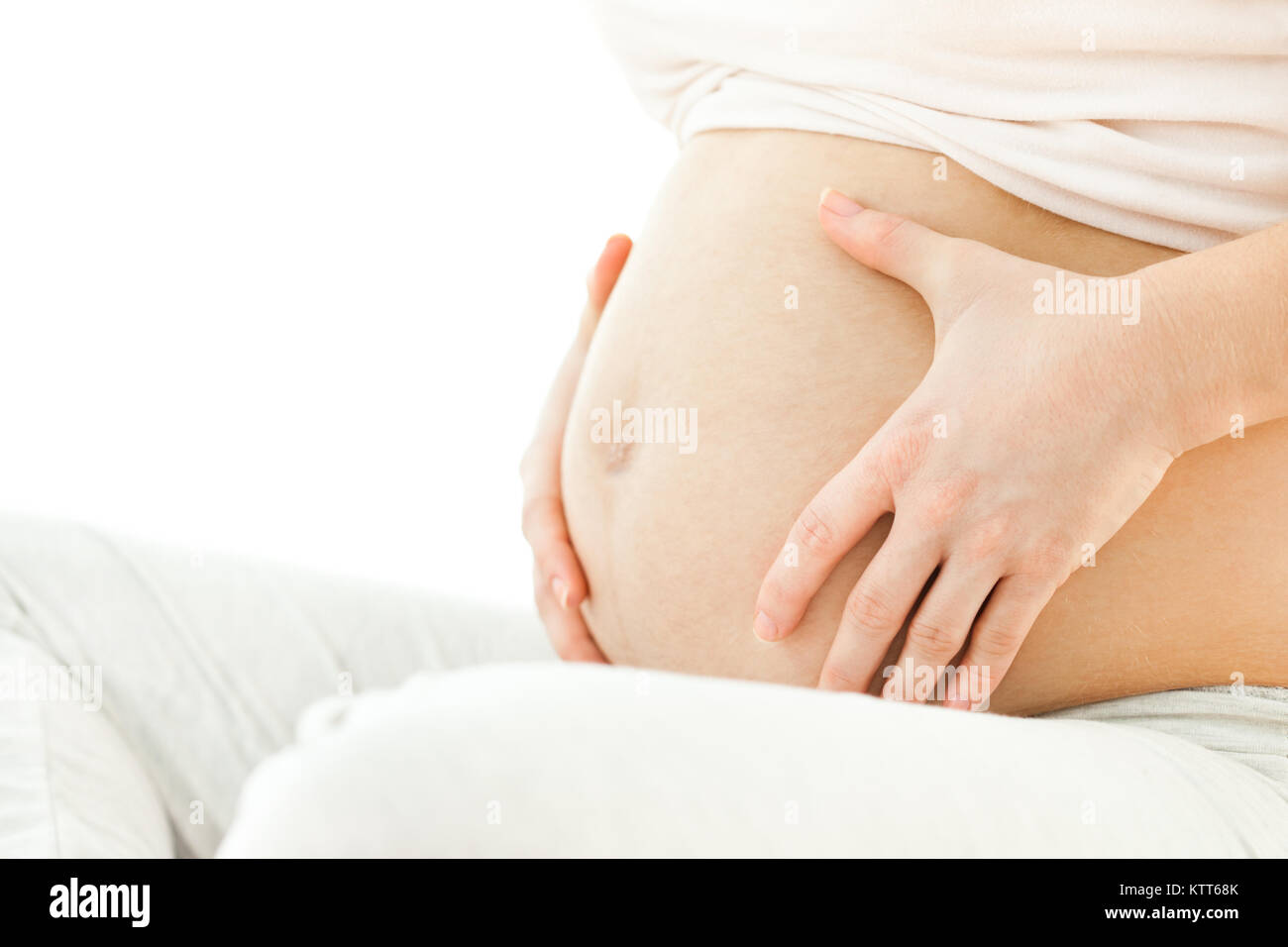 Pregnant woman holding her stomach Stock Photo - Alamy