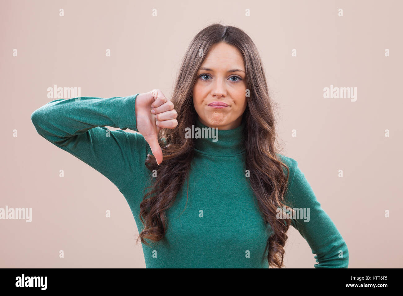 Portrait of displeased women who is showing thumb down Stock Photo