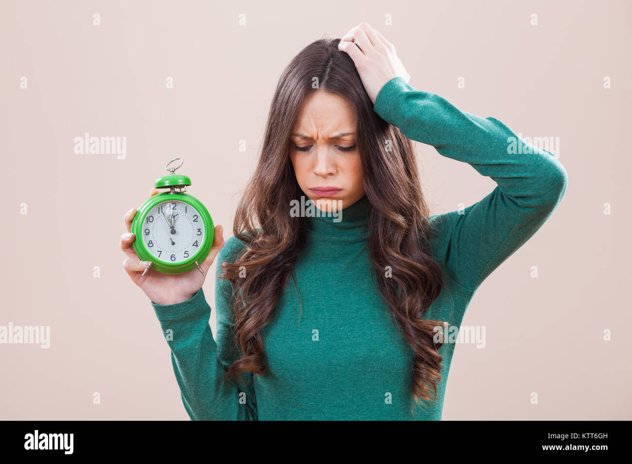 Woman holding clock that shows five to twelve time Stock Photo