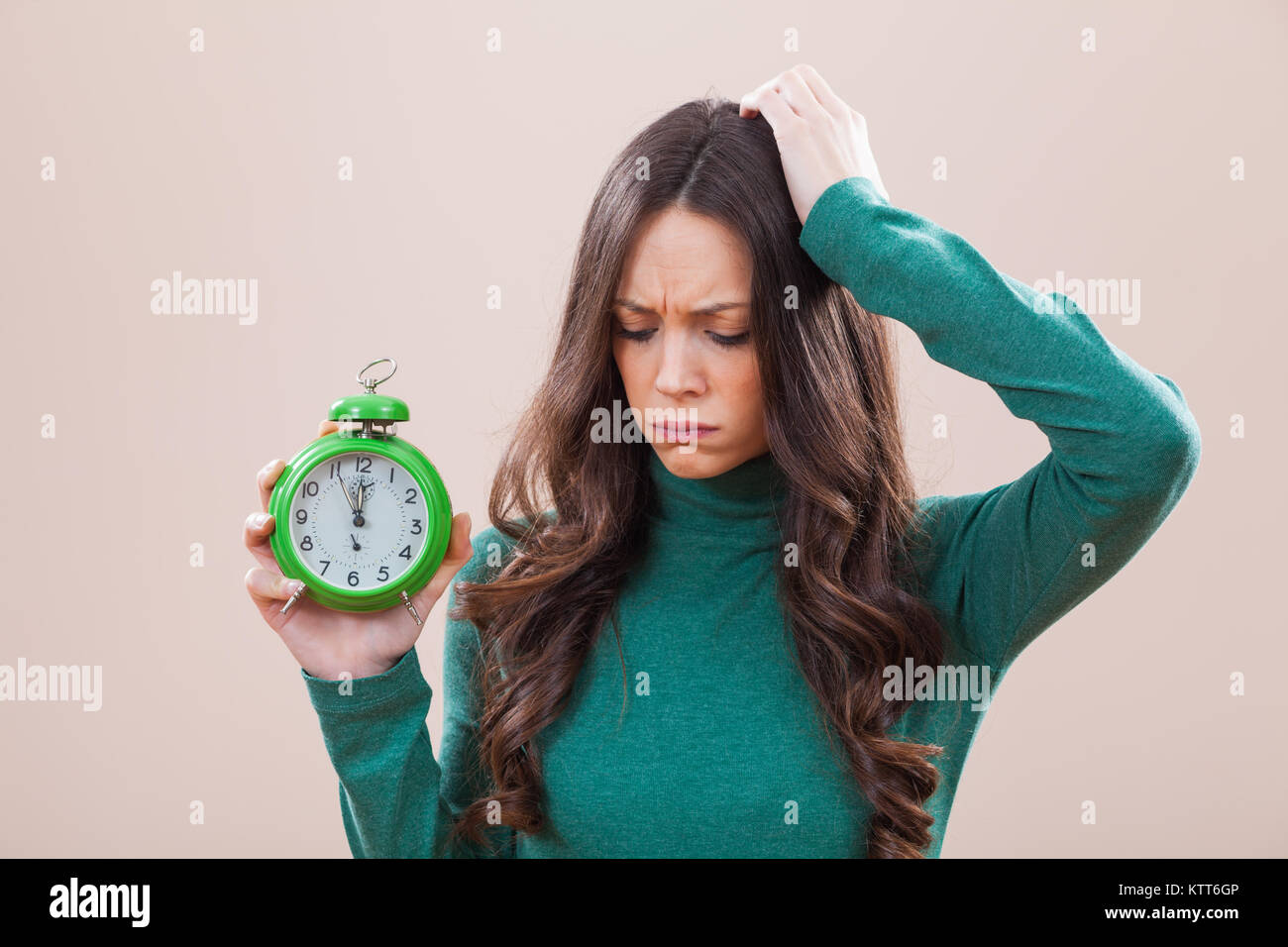 Woman holding clock that shows five to twelve time Stock Photo