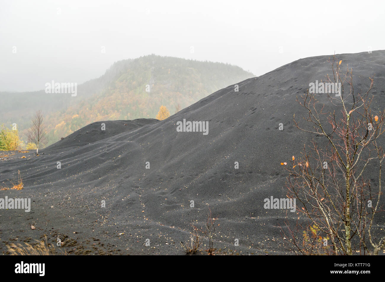 Slag heaps. Postindustrial landscape of abandoned nickel smelter in Evje, Norway, during foggy rainy day of late autumn. Stock Photo