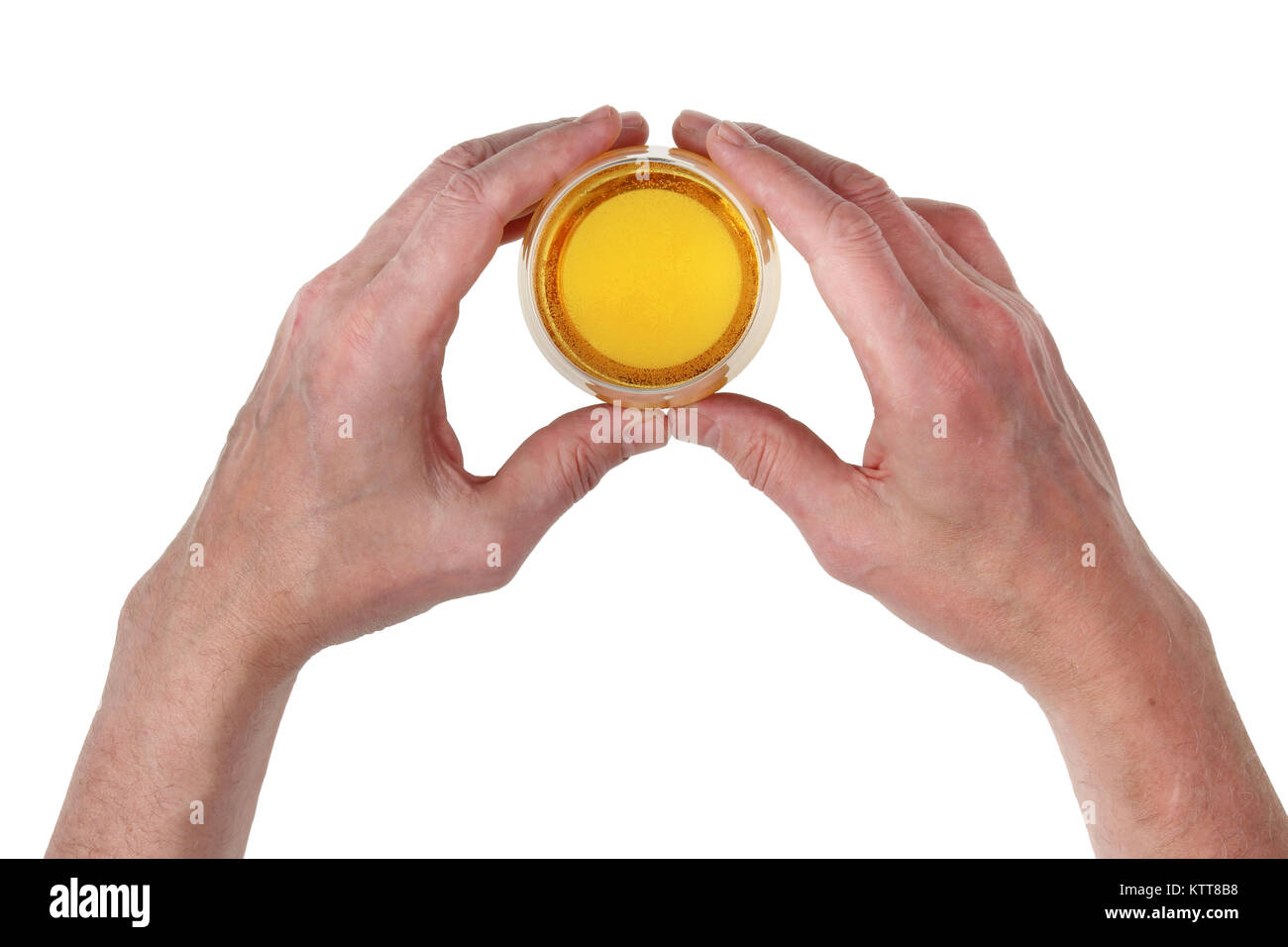 An elderly man in a bar holds his huge hands with a small glass of beer. Isolated top view studio concept Stock Photo