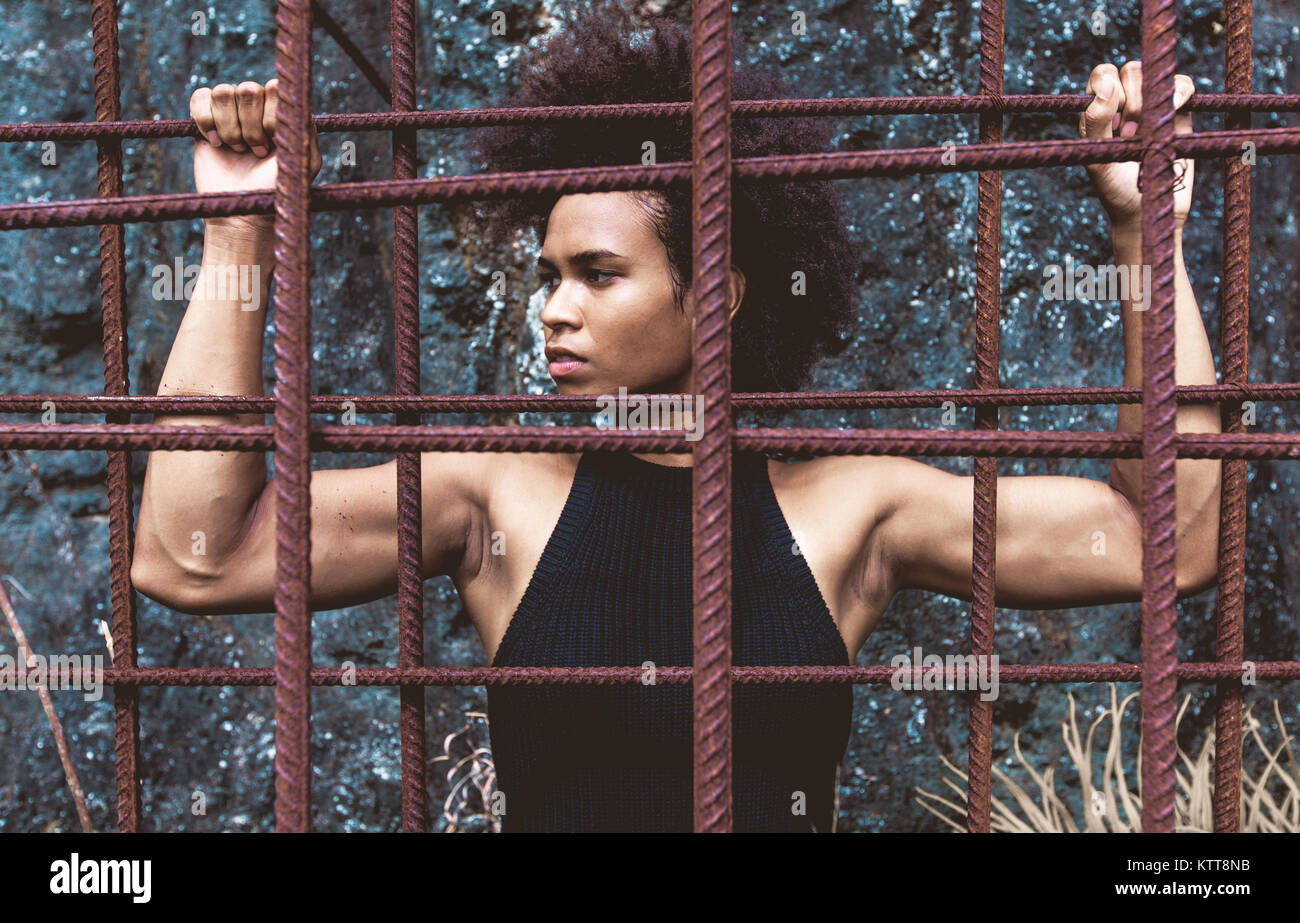 Afro american athlete girl with strong arms after workout behind iron
