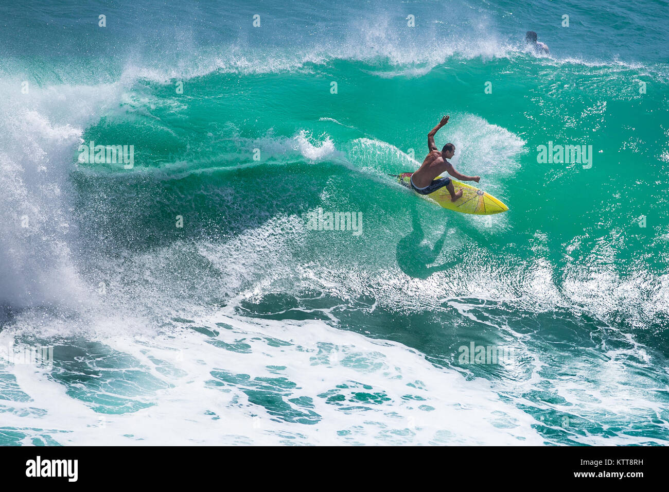 Surfer riding big green wave at Padang Padang beach, Bali, Indonesia Stock Photo