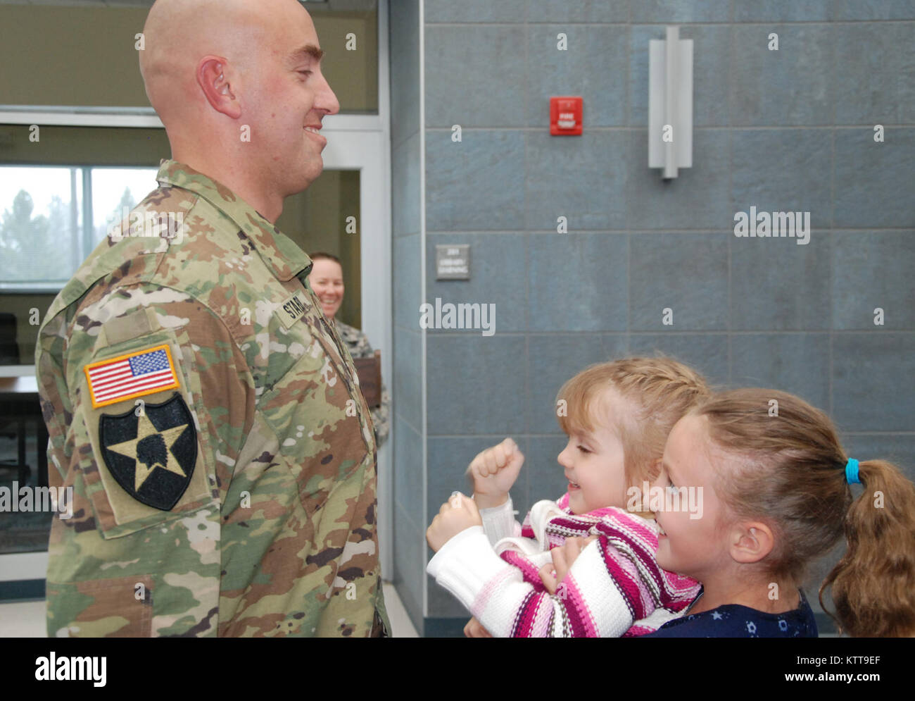 Maya Starr holds up her little sister Gwyn as they put new rank on their  father, Chief Warrant Officer 2 Matthew Starr during his promotion ceremony  on March 31, 2017 at New