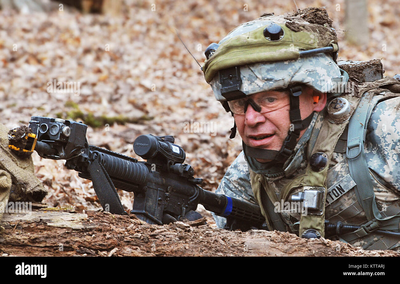 Staff Sgt. Chris Hatton of Headquarters and Headquarters Company 37th Infantry Brigade Combat Team peers above a log, looking for his next line of cover during premobilization training in the Ravenna Joint Military Training Center, April 8, 2011. Hatton participated in Individual Movement Techniques where soldiers performed such tasks as crawling under barbed wire, scaling a six foot wall, and crawling to cover. The training is to prepare the soldiers of the 37th for their scheduled yearlong deployment to Afghanistan in fall 2011 in support of Operation Enduring Freedom. (Ohio National Guard p Stock Photo