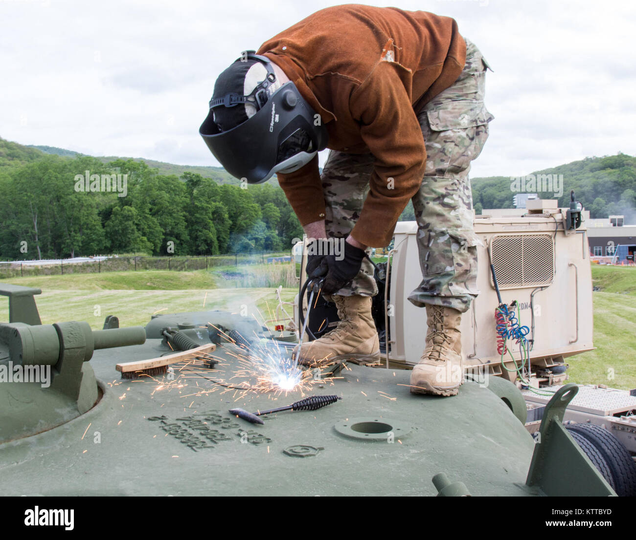 U.S. Army Staff Sgt. Cory Peck, a welder for the New York Maneuver Area Training Equipment Site at Ft. Drum and attached to the 1427th Transportation Company, New York Army National Guard, uses a striker to stick weld the hatch on a recently restored M48 tank on display at Camp Smith Training Site, Cortlandt Manor, N.Y., June 16, 2017. (U.S. Army National Guard photo by Staff Sgt. Michael Davis) Stock Photo