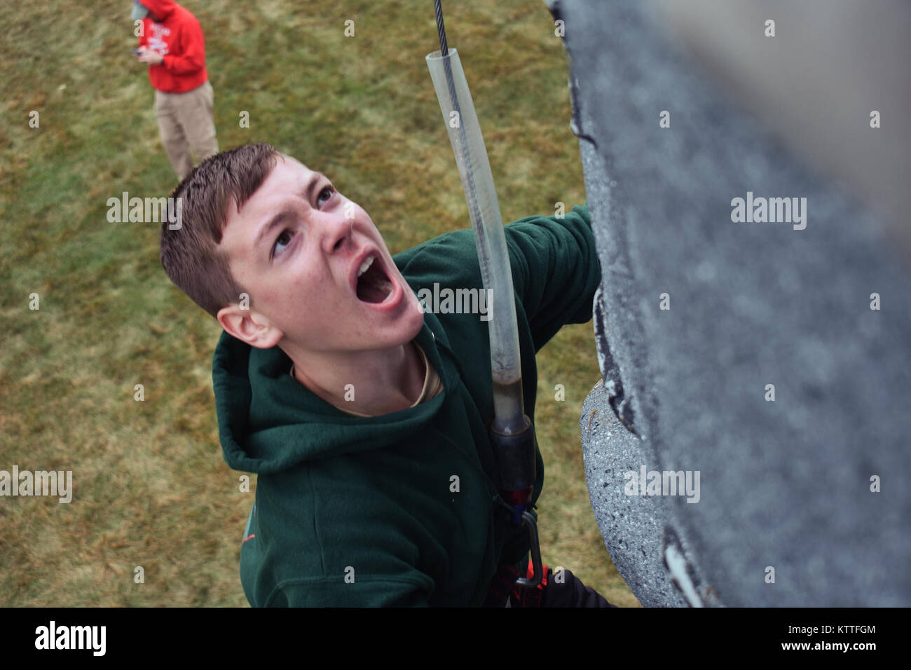 A Boy Scout climbs up a rock wall at the New York Army National Guard’s (NYARNG) Queensbury Armory, Queensbury, N.Y., Sept. 30, 2017.The boy scouts, on their annual camporee were learning about the NYARNG, and were able to participate in events like pulling a humvee, pull-up contests, an electronic range, and racing up a rock wall. (N.Y. Army National Guard photo by Pfc. Andrew Valenza) Stock Photo