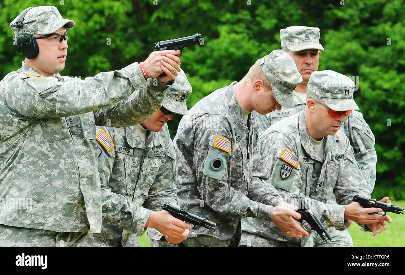 Chief Warrant Officer Zachary Slate fires his M9 pistol as his teammates, (left to right) Sgt. 1st Class Jason Frater, Sgt. George Hess and Capt. Bret Gould, unload theirs during the annual Adjutant General's Combat Pistol Match at the Camp Sherman Joint Training Center in Chillicothe, Ohio, May 8, 2010. They were four of 13 Soldiers in the 37th Infantry Brigade Combat Team, Headquarters and Headquarters Company pistol team, which won first place in both the General George Patton match and Adjutant General Ashenhurst Team Championship. (Ohio National Guard photo by Spc. Kimberly Lamb) (Release Stock Photo