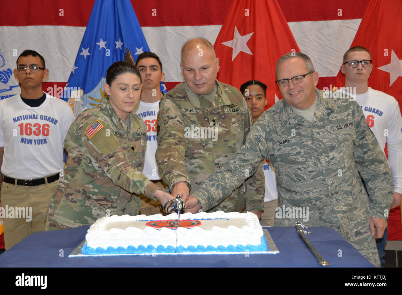 Maj. Gen. Raymond Shields, assistant adjutant general, Army, of New York (middle) joins the oldest and newest members of the New York National Guard to cut a cake in celebration of the National Guard’s 381th birthday at New York National Guard headquarters in Latham, N.Y. on December, 13 2017. The National Guard was established in 1636 and is the oldest military force in the Department of Defense. The new and old members are Spc. Jade Richards, age 19, New York Army National Guard (left); Chief Master Sgt. Michael Blake, one of the New York Air National Guard’s oldest serving Soldiers (right). Stock Photo
