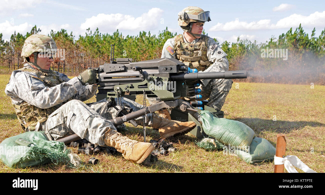 Spc. Patrick L. Noel of Cincinnati, Ohio, continues to fire as his assistant gunner, Spc. Philip J. Gavin of Newark, Ohio, Personal Security Detail Soldiers assigned to Headquarters and Headquarters Company, 37th Infantry Brigade Combat Team, feeds ammunition to their MK19 machine gun during qualification at Camp Shelby Joint Forces Training Center, Miss., Nov. 16, 2011. The 37th IBCT is deploying to Afghanistan in support of Operation Enduring Freedom. (37th IBCT photo by Sgt. Kimberly Lamb) (Released) Stock Photo