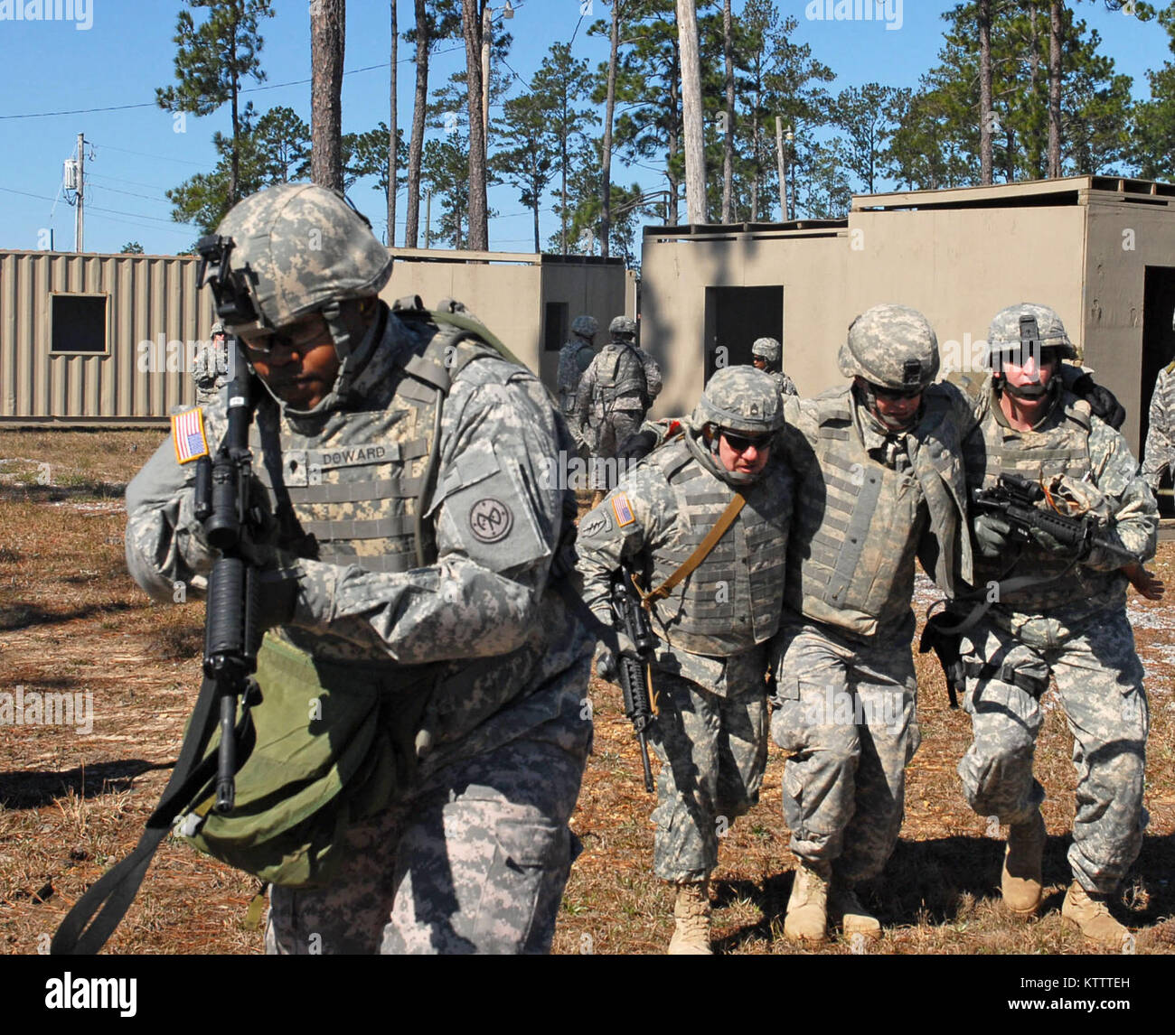 CAMP SHELBY, MS -- Spc. Charles Doward, far left, provides security for Sgt. 1st Class Vince Tomasella, left, and Master John Tyler, right, as they carry a mock casualty to a casualty collection point during combat lifesaver training here on Feb. 11. Sgt. 1st Class Kevin Black is playing the casualty, and all four Soldiers belong to Headquarters and Headquarters Company, 27th Infantry Brigade Combat Team. Doward is from Brooklyn, N.Y., Tomasella is from Rochester, N.Y., Tyler is from Adams, N.Y. and Black is from Kenmore, N.Y.  (Photo by Sgt. 1st Class Raymond Drumsta, 27th IBCT Public Affairs Stock Photo