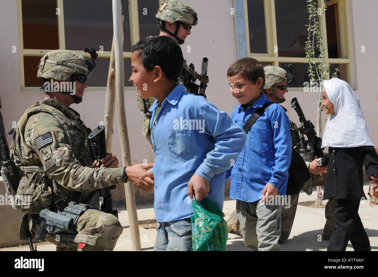 Sgt. 1st Class Grant Burtch, platoon sergeant for the personal security detail, Lt. Col. Joseph Gabriel, operations officer, and Sgt. John Dewey, team leader for the PSD, all assigned to Headquarters Company, 37th Infantry Brigade Combat Team shake hands with students as they leave the Aliabad School near Mazar-e-Sharif, Balkh Province, Afghanistan, April 3, 2012. A new school is being built for the students as one of the 37th's commander's emergency relief program projects. The 37th IBCT is deployed to Afghanistan in support of Operation Enduring Freedom. (37th IBCT photo by Sgt. Kimberly Lam Stock Photo