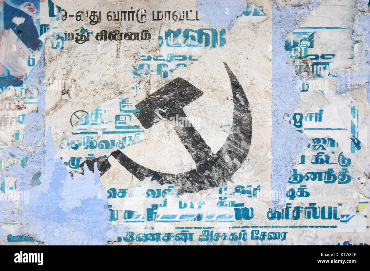 faded communist hammer and sickle on wall poster in India Stock Photo