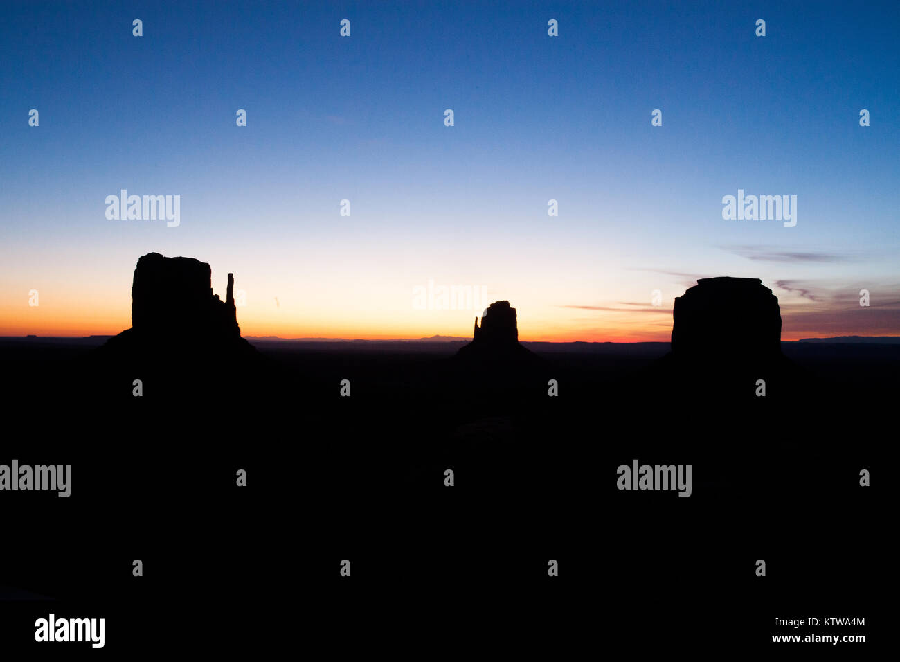 MONUMENT VALLEY, ARIZONA/UTAH BORDER USA. - APRIL 2015: Sunrise starts to peek over the horizon behind the buttes of Monument Valley. Stock Photo