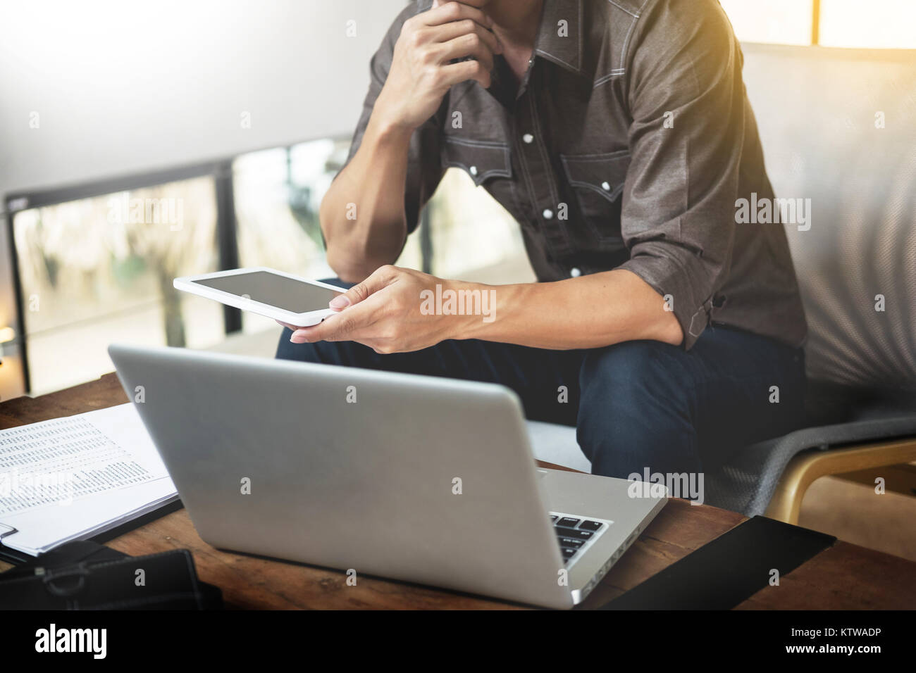 Modern businessman with tablet computer reading news and work report ...