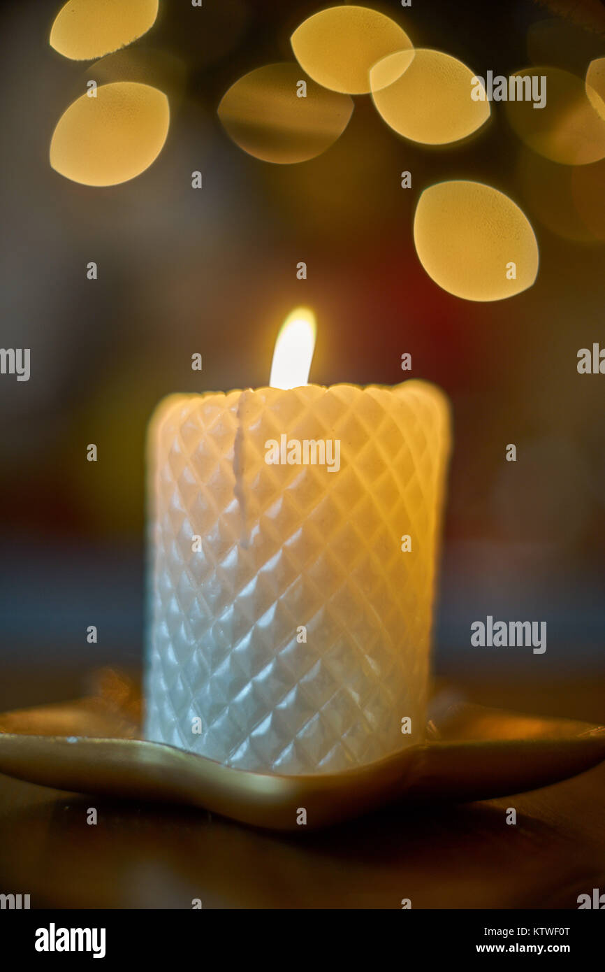 Burning candle on a background of blurred lights Stock Photo - Alamy