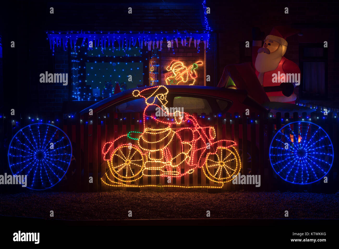 Santa claus riding a motorbike christmas lights on a house in the
