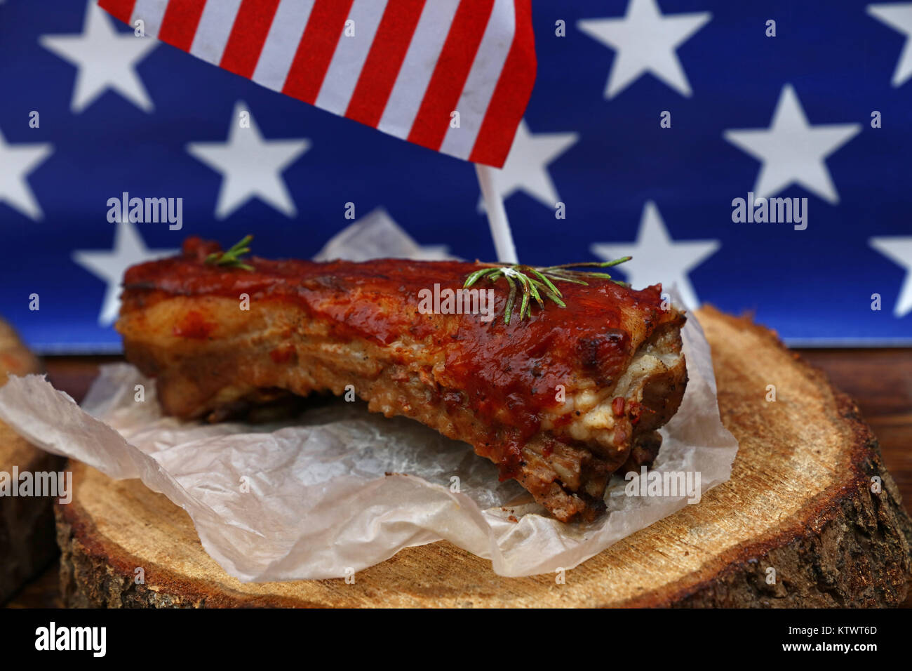 Portion of cooked pork spare ribs in bbq sauce on paper parchment and