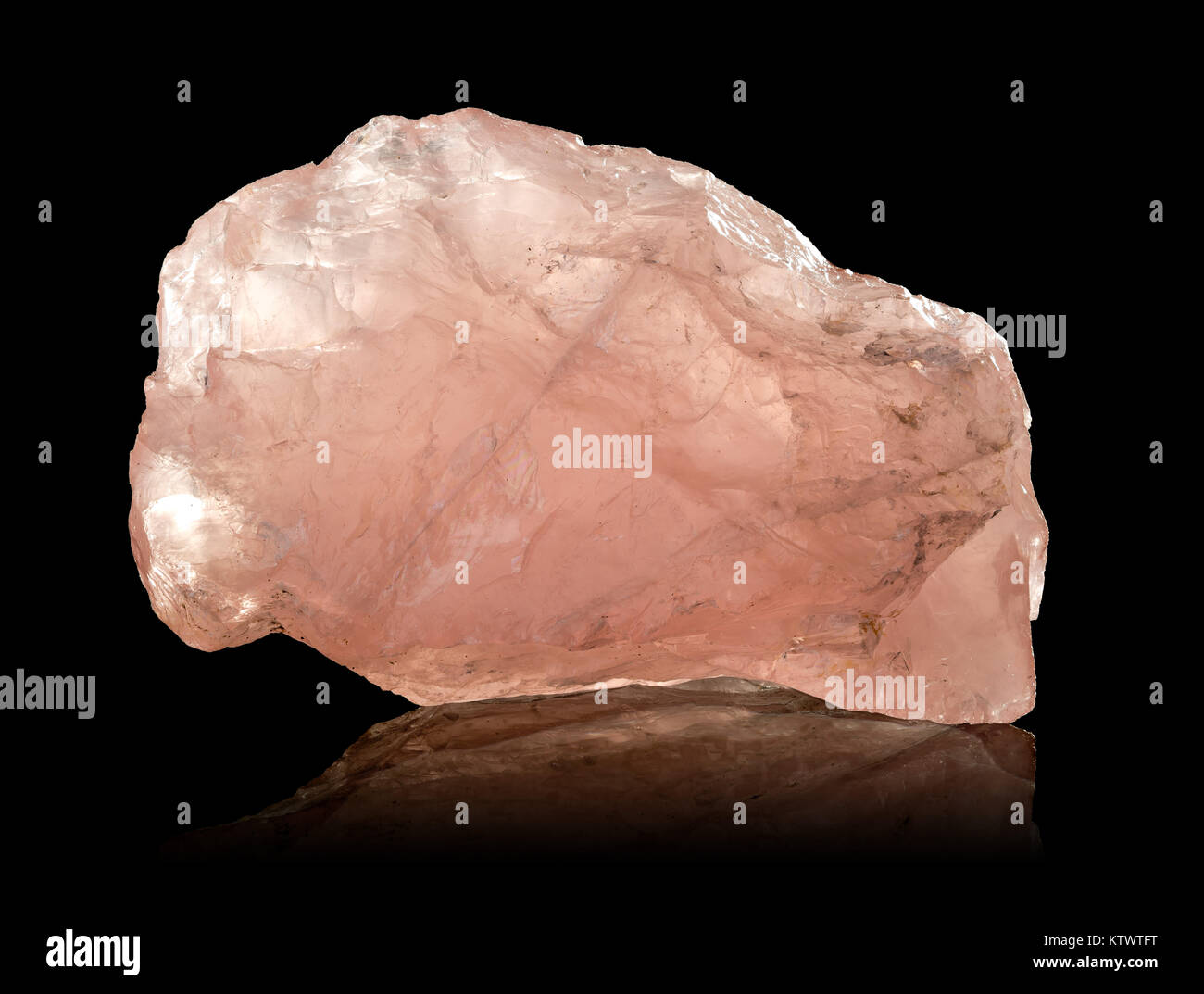 Raw, uncut rose quartz crystal over black background Stock Photo