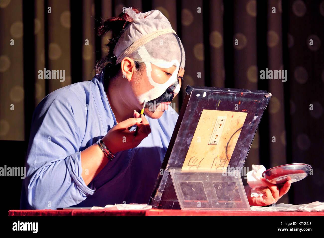 A Peking Opera actor applying makeup, Liyuan Theatre, Beijing, China Stock Photo