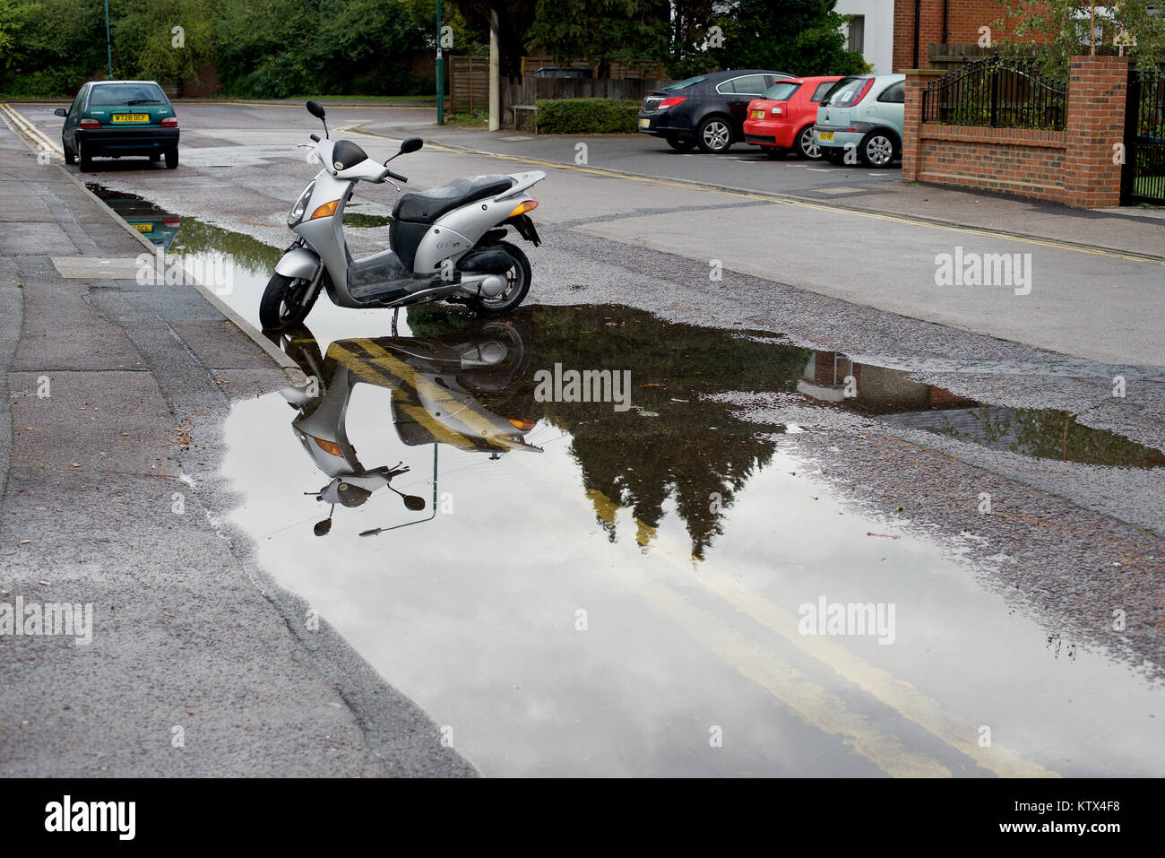 Street with a scooter in rain water Stock Photo Alamy