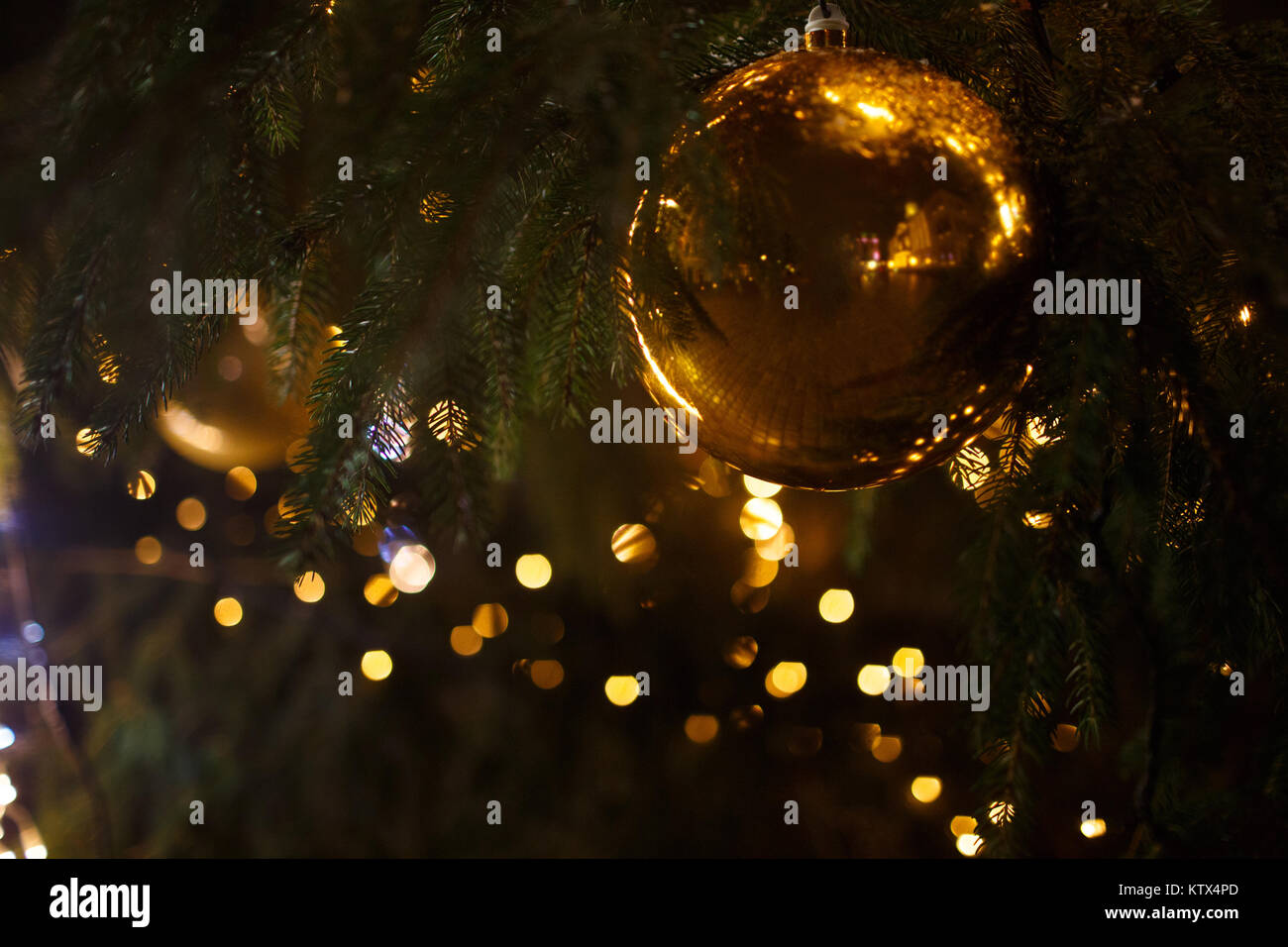 Decorated Christmas tree closeup. Golden ball and illuminated garland ...