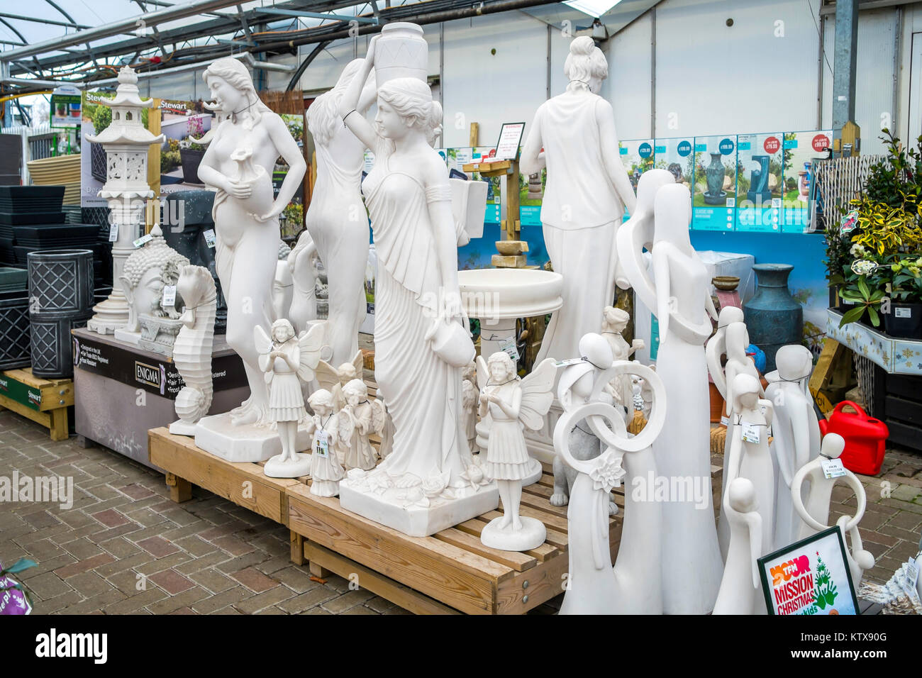 A collection of classical reproduction female garden ornament statues for sale in a Garden