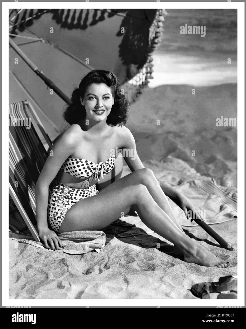 AVA GARDNER Vintage 1940's Hollywood Actress Ava Gardner lounges on the studio beach in a polka dot bikini 1944 Stock Photo