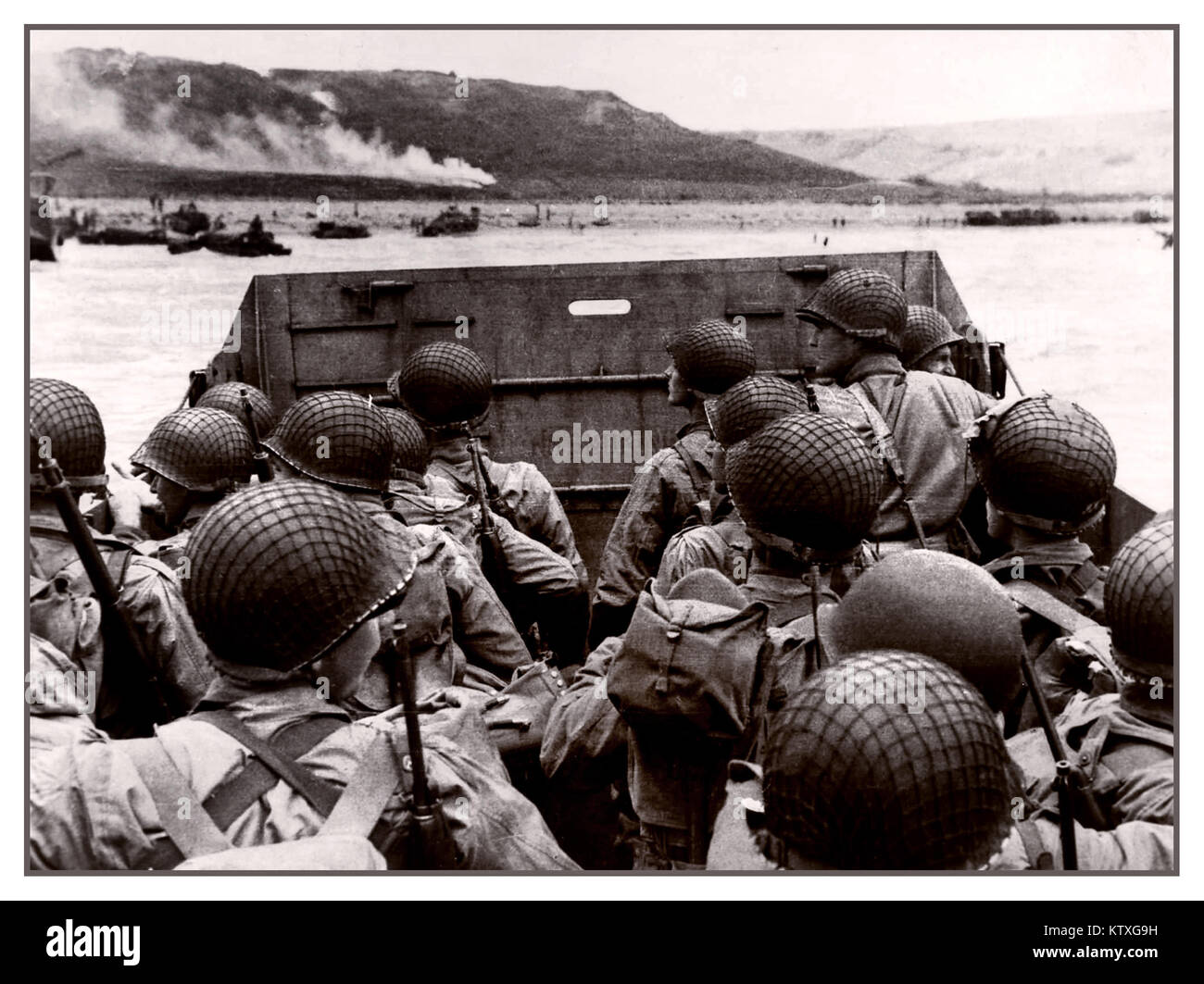 D-Day Omaha invasion beach landing craft under dull skies with American troops in landing craft visually guided by smoke flares approaching Omaha Beach Normandy France 6th June 1944 Stock Photo