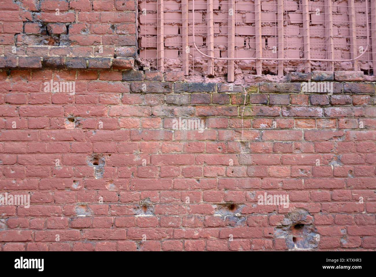 Brick wall with bullet marks, closeup Stock Photo