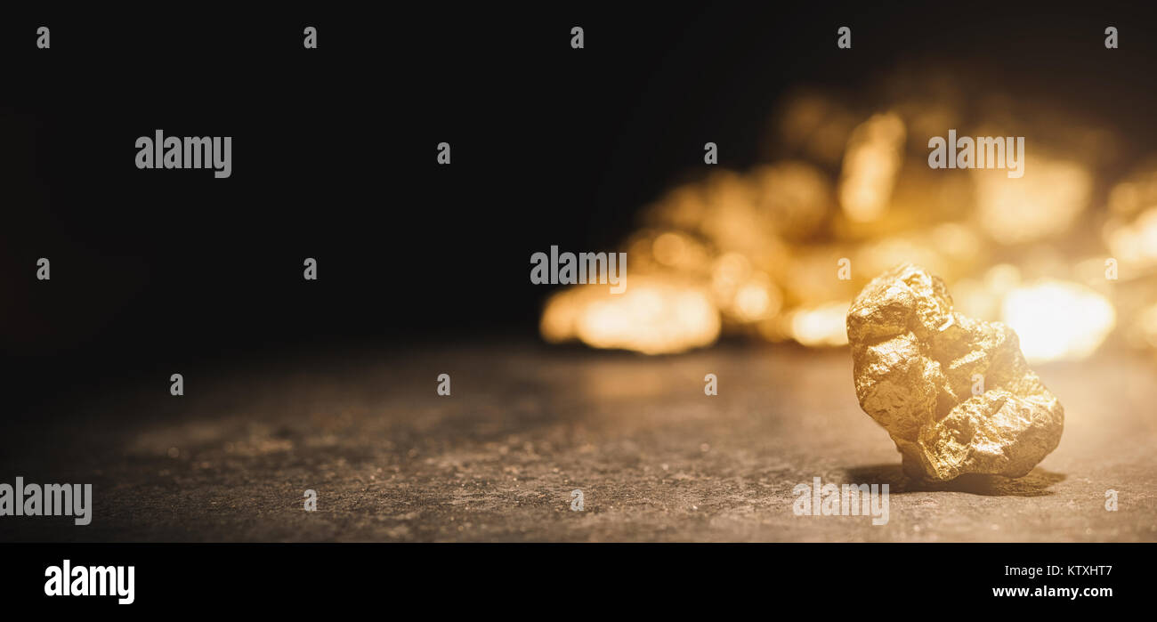 gold nugget in front of a mound of gold Stock Photo